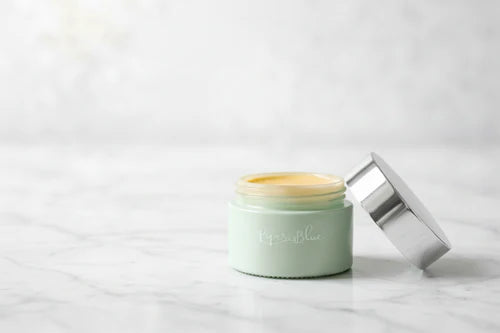 Green jar with a silver lid on a white background