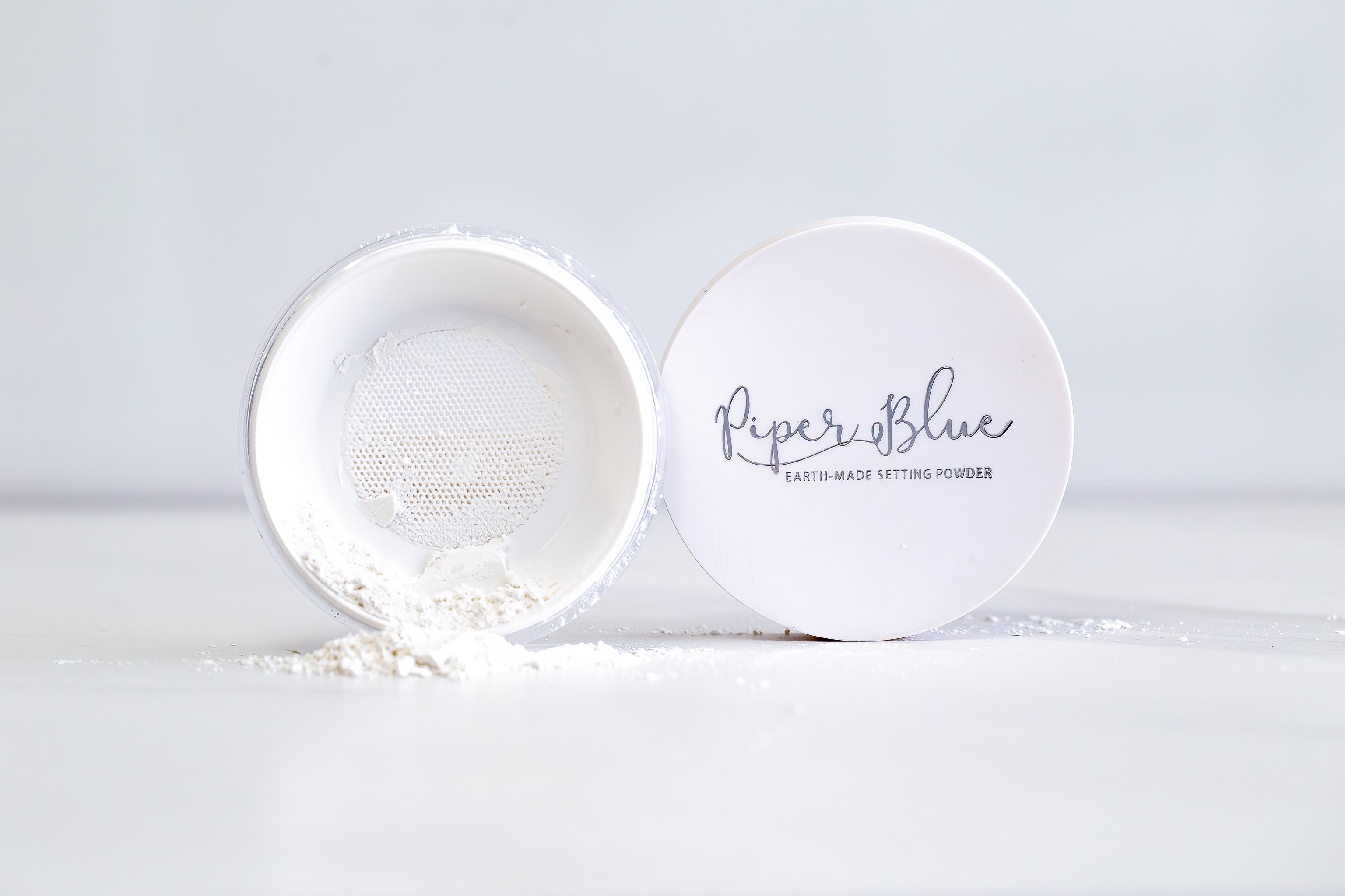 PiperBlue earth-made setting powder with a white container on a light gray background