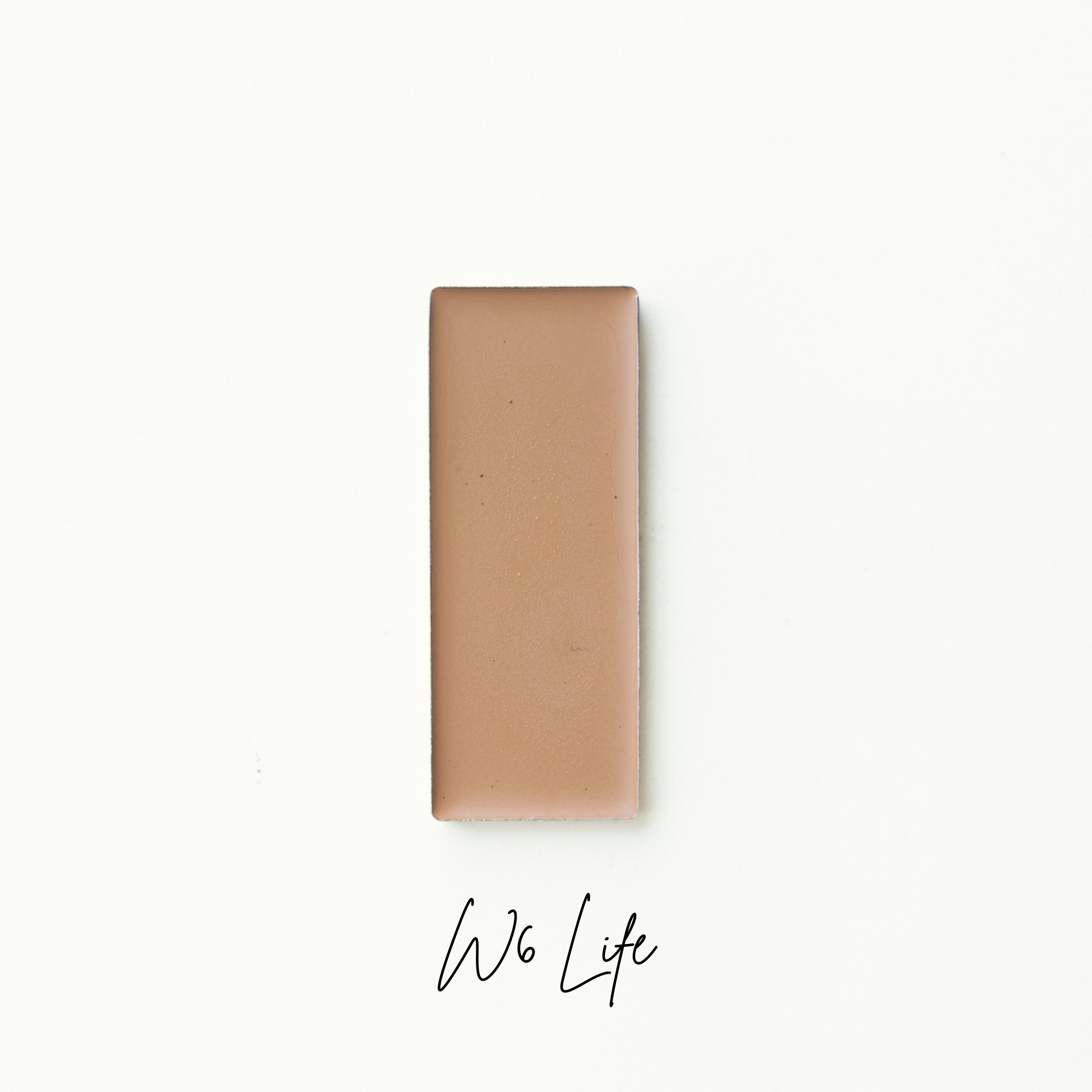 Rectangular brown bar of foundation on a white background with 'W6 Life' branding. natural makeup